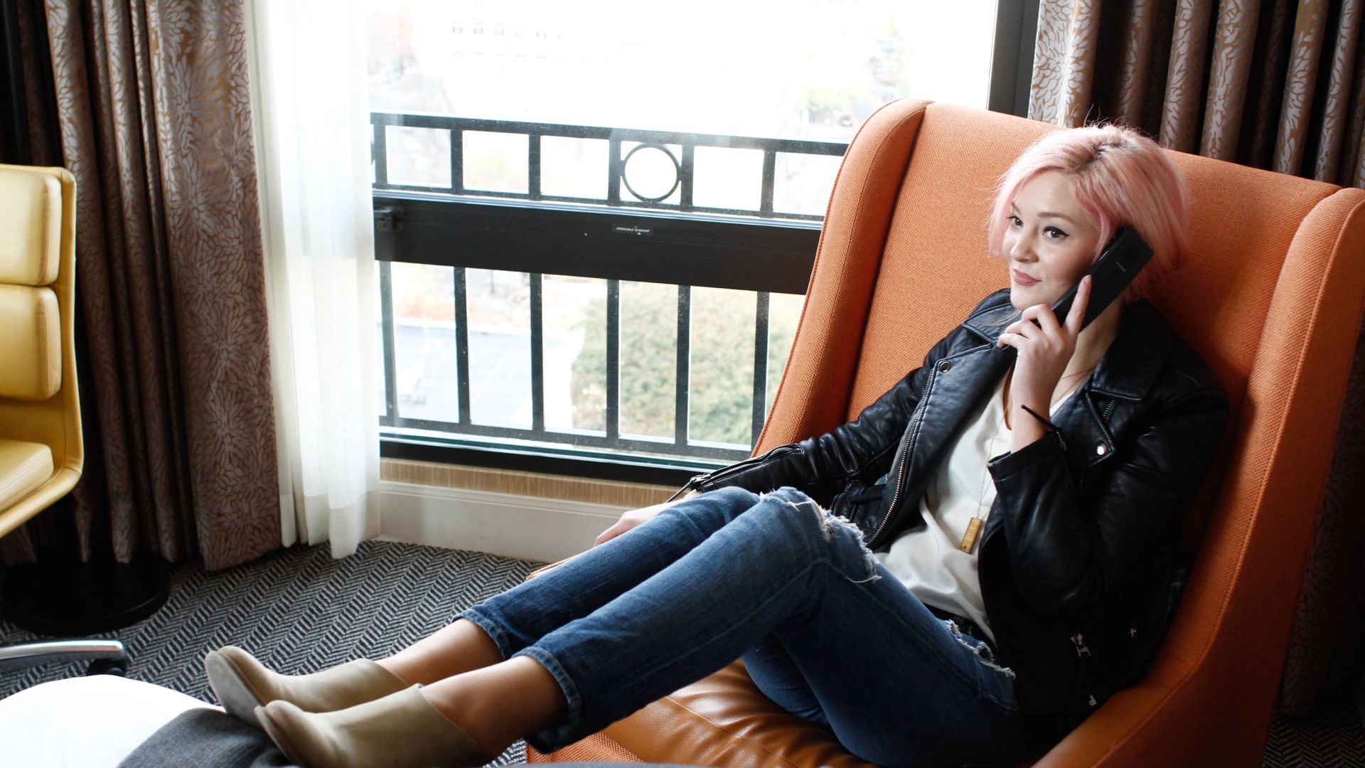 A Woman Sitting In A Chair Talking On A Cell Phone